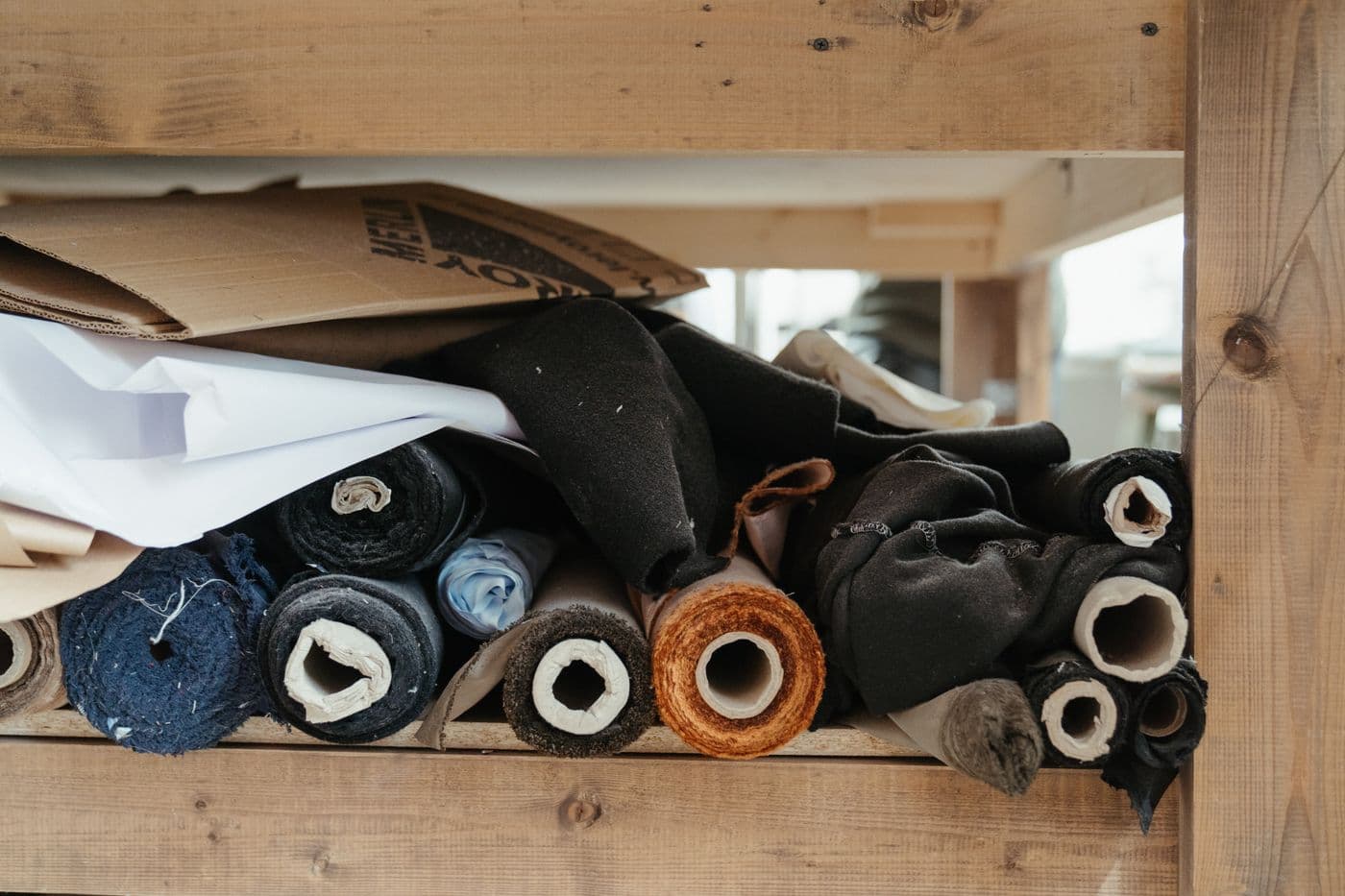 Rolls of fabric on a workshop shelf